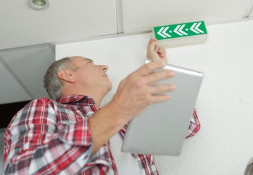 Man checking emergency signs in building