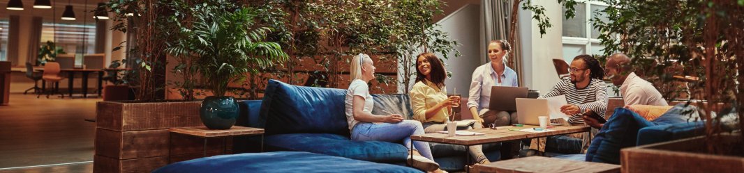 Three women sitting and talking in a clean meeting area.