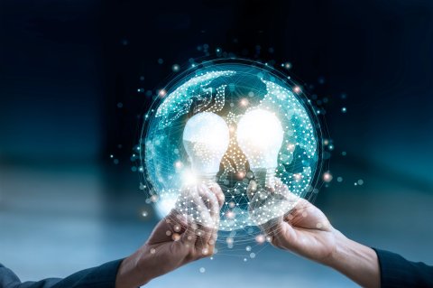 Two hands holding glowing light bulbs within a digital globe.