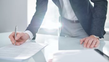 Man signing a document on a desk