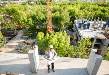 Construction site building with a engineer standing on top 