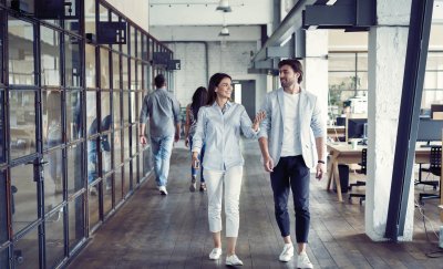 Man and woman walking in a office building.