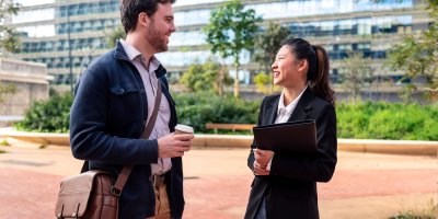 Coworkers chatting in front of an office building.