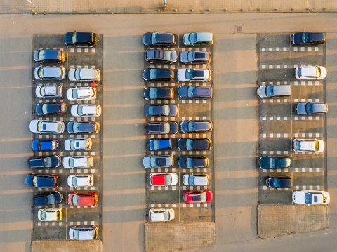 Parking lot with a fleet of cars parked in rows.
