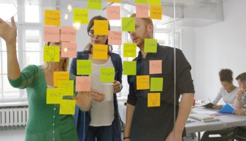 Colleagues brainstorming with sticky notes in a flexible workspace