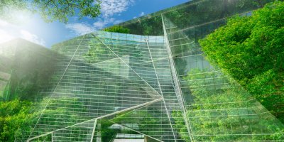 Sustainable glass office building with trees for reducing carbon dioxide.