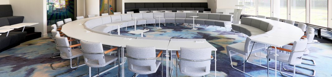 Meeting room with conference tables in a circle.