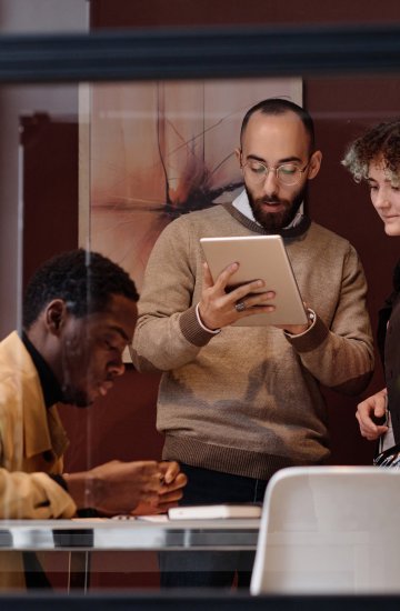 Three businesspeople in a stylish office with plants.