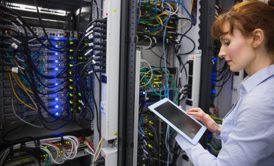 Maintenance worker doing a server check on a tablet