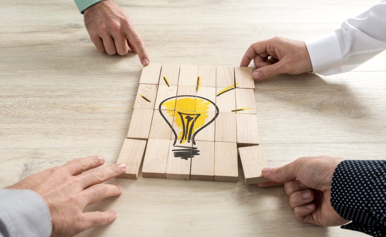 People doing a puzzle representing a light to demonstrate team work and conceptual ideas