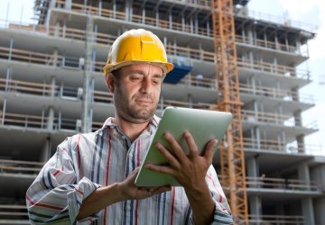 Field engineer looks at his tablet to check work orders.