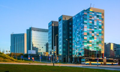 Glass midrise office building with colorful windows reflecting the sky