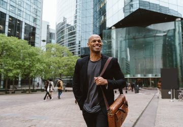 Young business man walking in front of building 