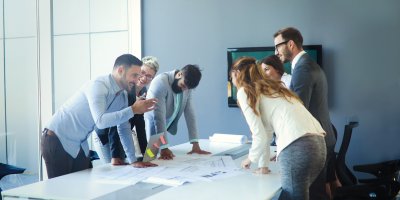 People having a group discussion around a meeting table about workplace management.