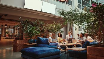 Three women sitting and talking in a clean meeting area.