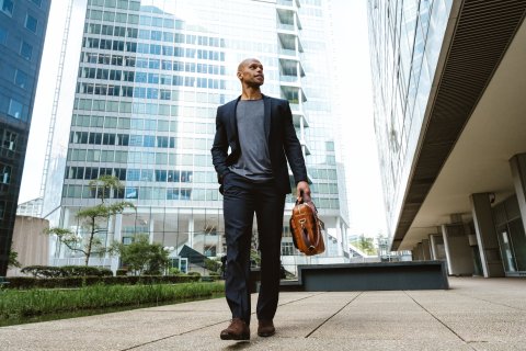 Young businessman walking to work in the morning, dressed in professional attire.