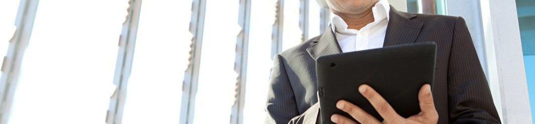 Businessman looking at a tablet in his hands.