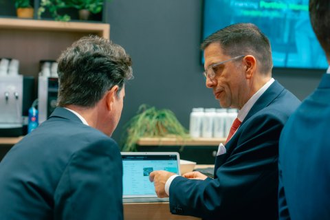 Person giving a presentation about software to visitors at an exhibition booth.