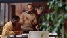 Three businesspeople in a stylish office with plants.