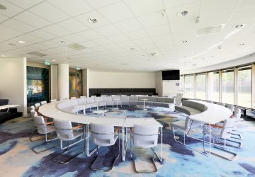 Meeting room with conference tables in a circle.