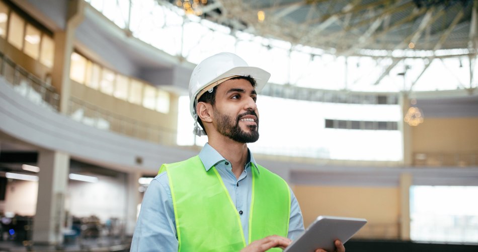 Engineer working on tablet by building inspection