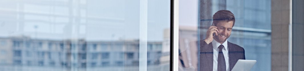 Man on the phone holding iPad in workspace