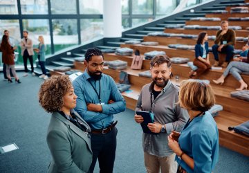 Group of people talking in an auditorium at a university.
