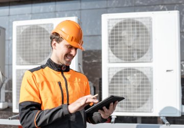 Maintenance worker checking air conditioning data on a tablet