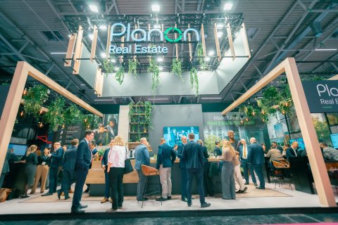 Visitors standing and talking at Planon Real Estate's booth at EXPO REAL.