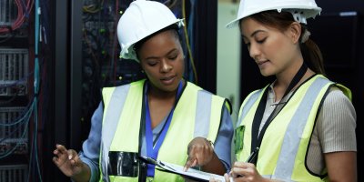 Two female maintenance engineers checking their work orders.