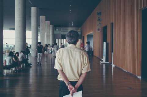 Teacher walking in the corridor of an educational facility.