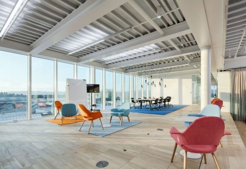 Colorful open meeting place with large glass windows.