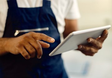 Close up mechanic working on tablet