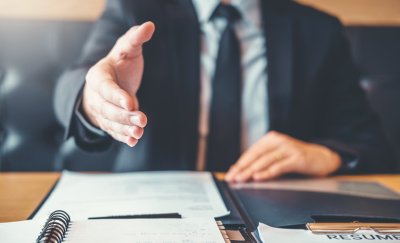 Man giving hand shake after signing contract.