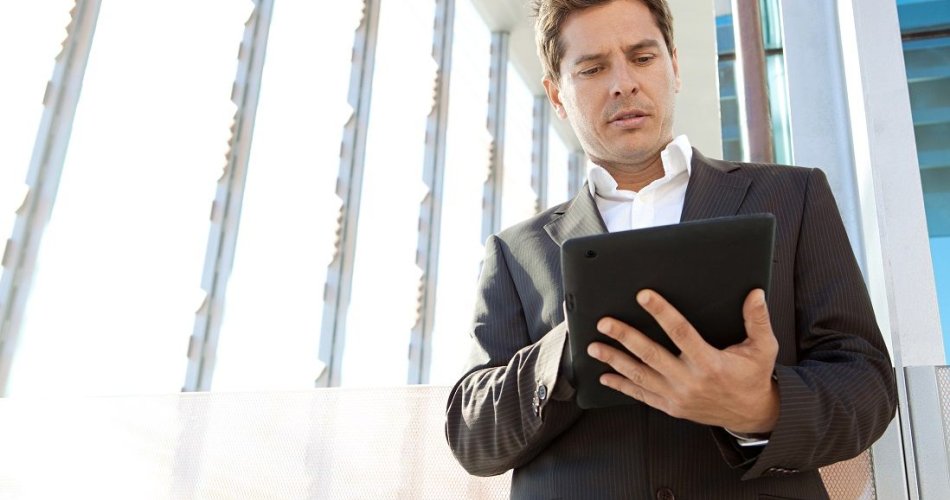 Businessman looking at a tablet in his hands.