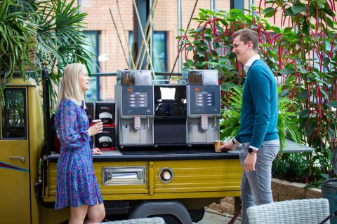 Two Planon employees chatting at the coffee machine