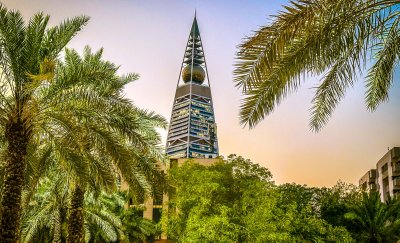 Image showing the Al-Faisaliah-Tower in Riyadh with lots of green plants and palmtrees.