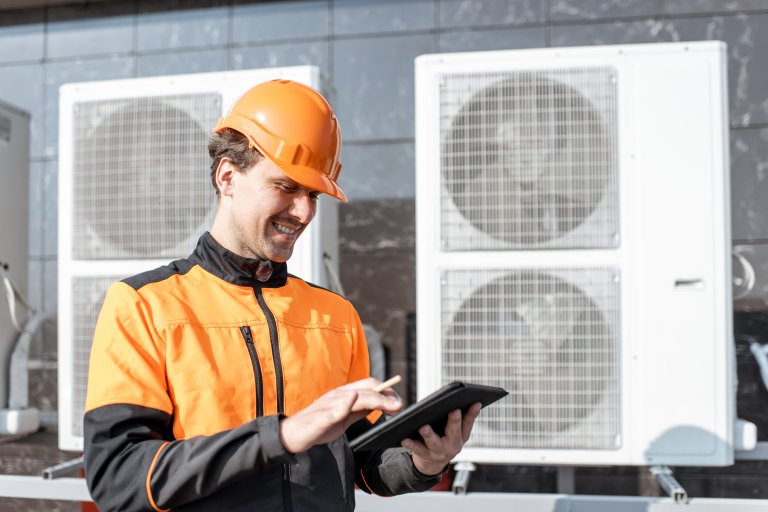 Maintenance worker checking air conditioning data on a tablet