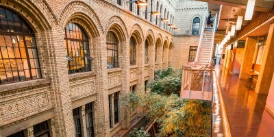 Beautiful green trees in a passage of a building with an orange glow..