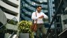 Business man looking at his watch in front of real estate buildings