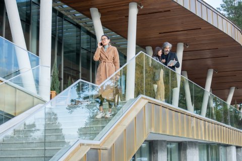 Business woman calling on stairs in front of real estate building