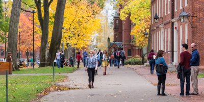 People walking on the campus road with University real estate building.