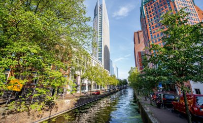 Tall buildings next to Dutch canals with trees