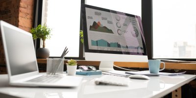 Desk with laptop showing data charts and data analytics.