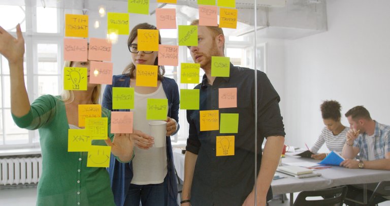 Colleagues brainstorming with sticky notes in a flexible workspace