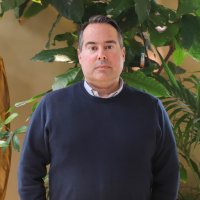 Roel Kruijtzer, HR employee at Planon, standing in a green house.