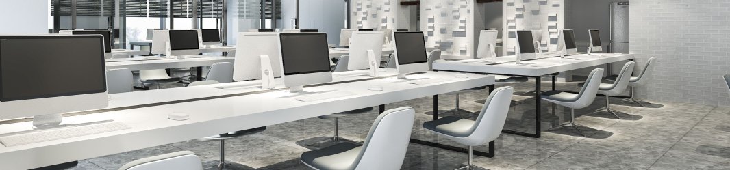 Clean white workspace with multiple empty workstations. 