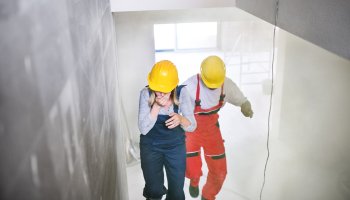 People running on stairs with smoke in building