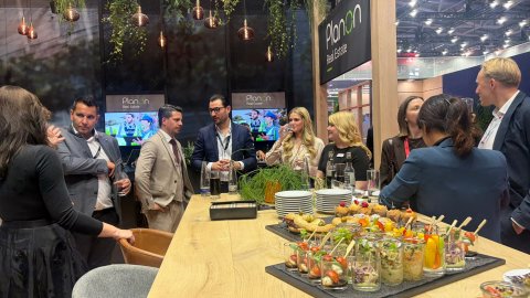 Visitors and event staff gathering around the catering counter during a networking event.