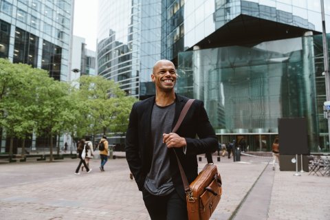 Young business man walking in front of building 